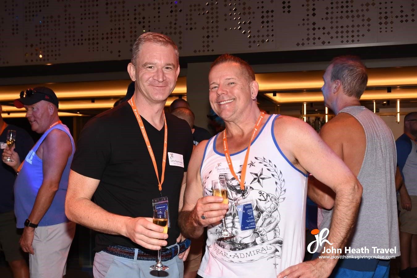 Two men are standing next to each other holding glasses of champagne.