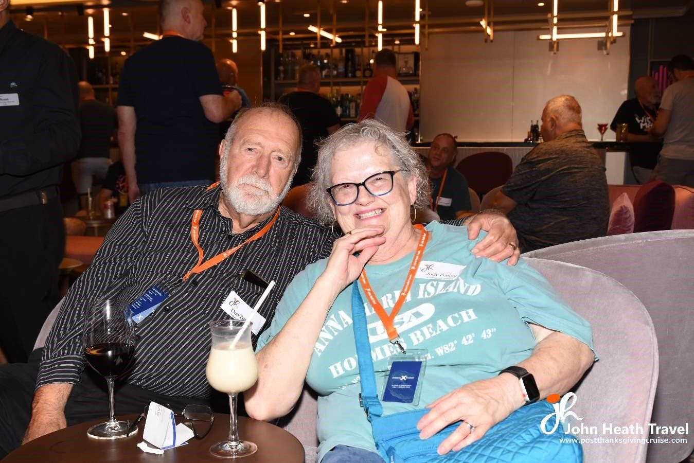 A man and a woman are sitting on a couch with a glass of wine.