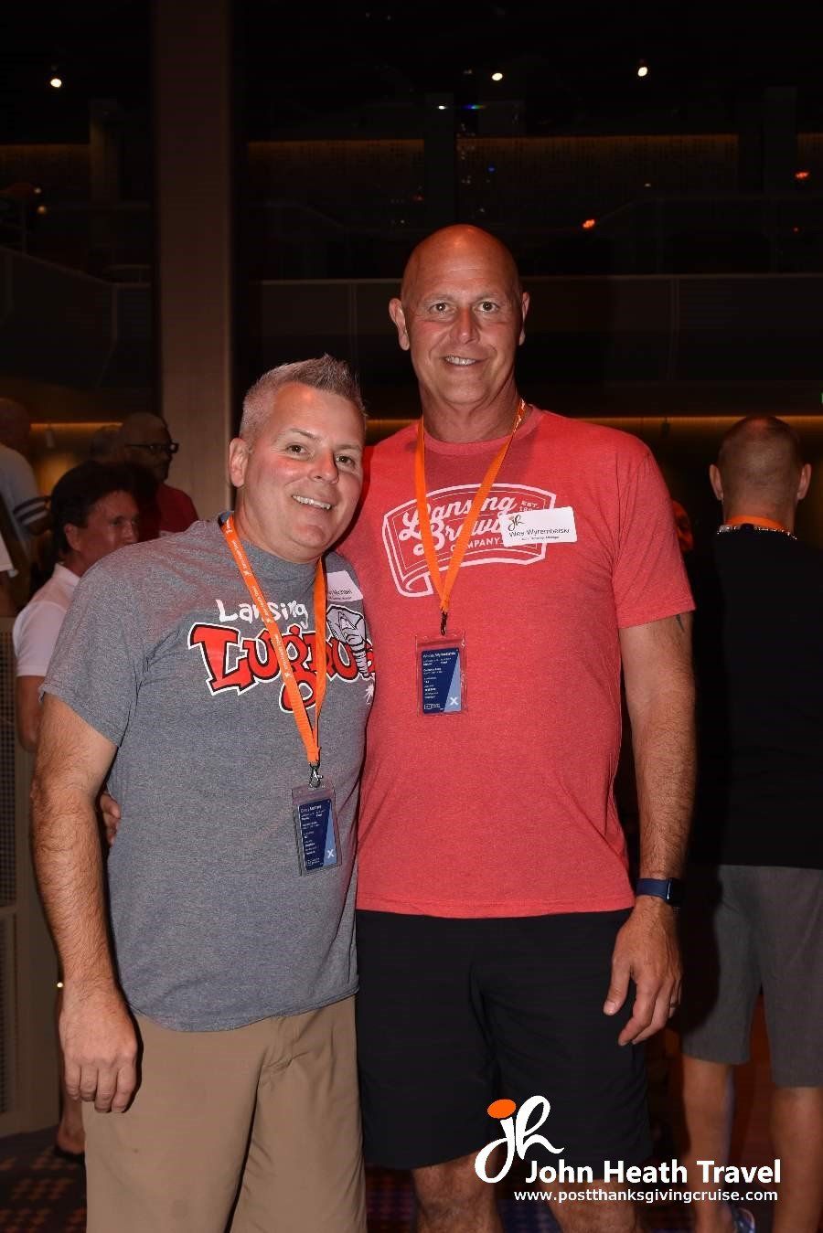 Two men are posing for a picture together in a dark room.