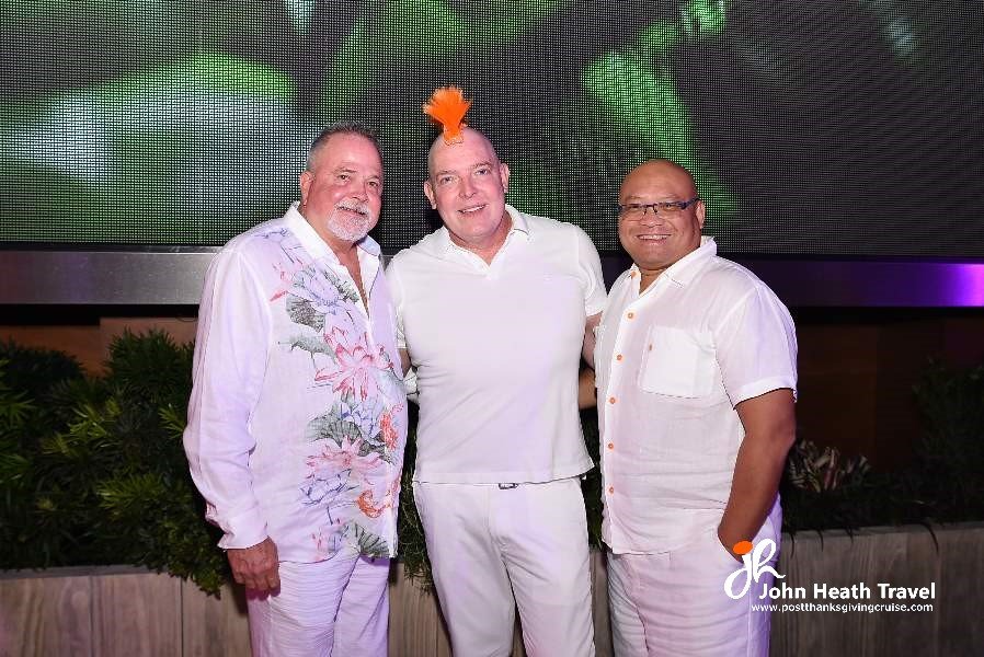Three men in white shirts are posing for a picture.