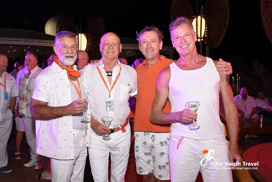 A group of men in white shirts and shorts are posing for a picture.