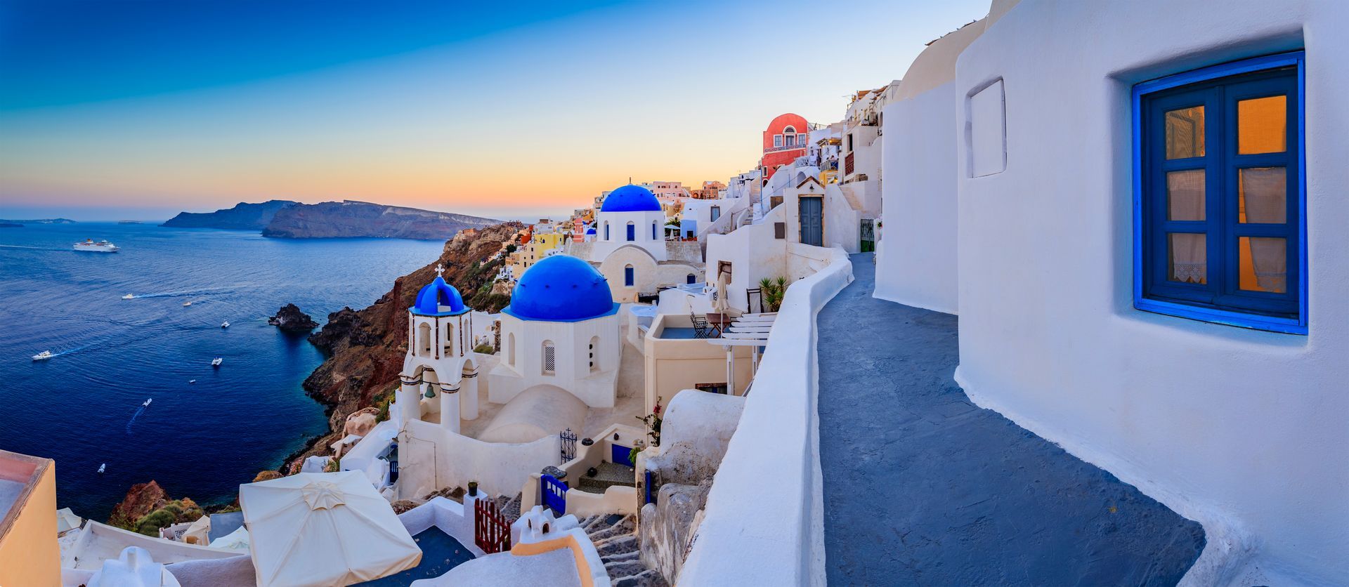 A view of santorini , greece , from a balcony overlooking the ocean.