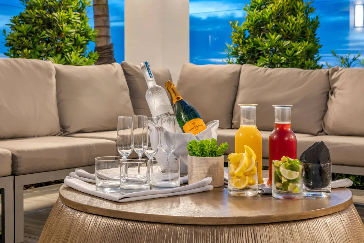 A table with a tray of drinks and a bottle of champagne on it.