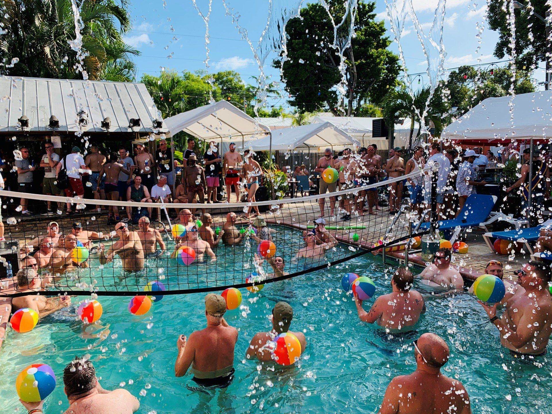 A group of people are playing volleyball in a pool.