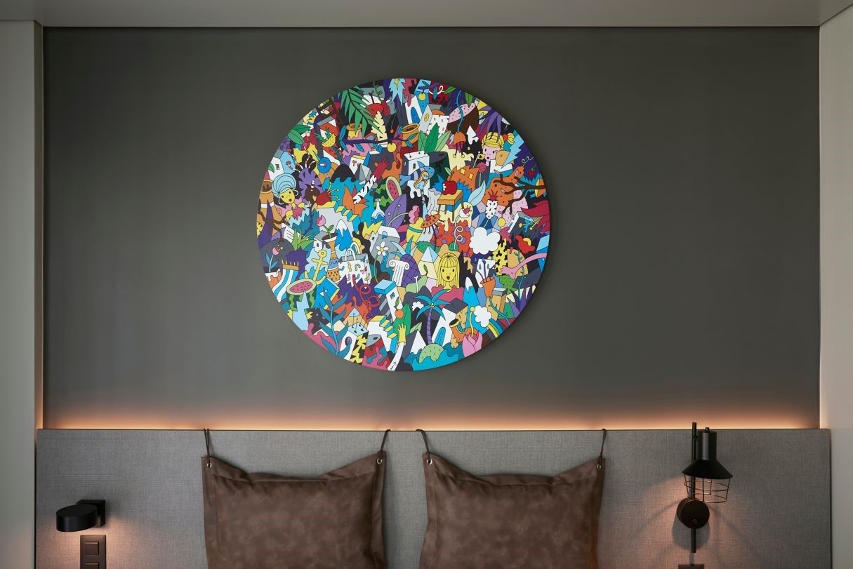 There is a painting on the wall above the bed.