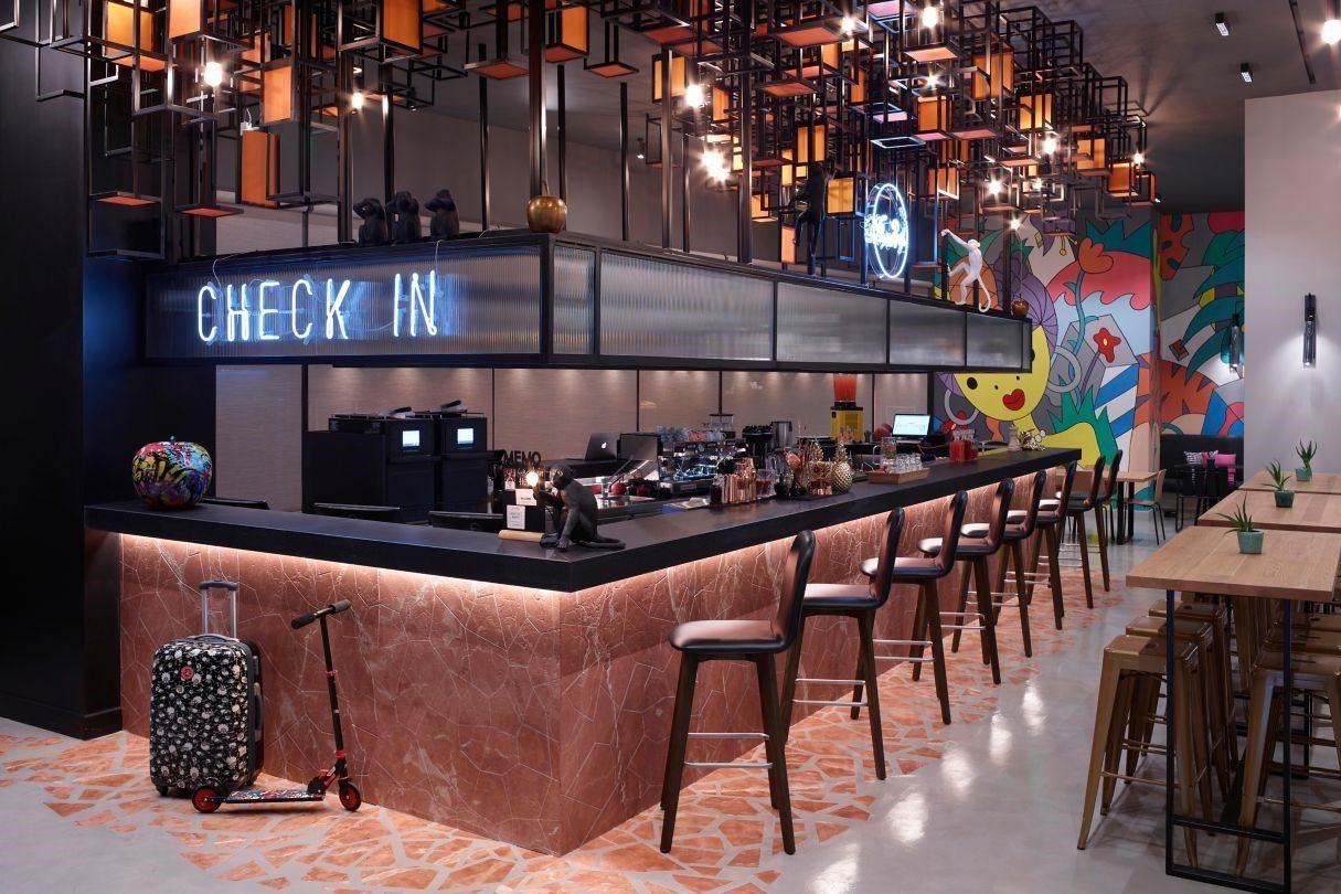 A restaurant with a check in counter and tables and chairs.