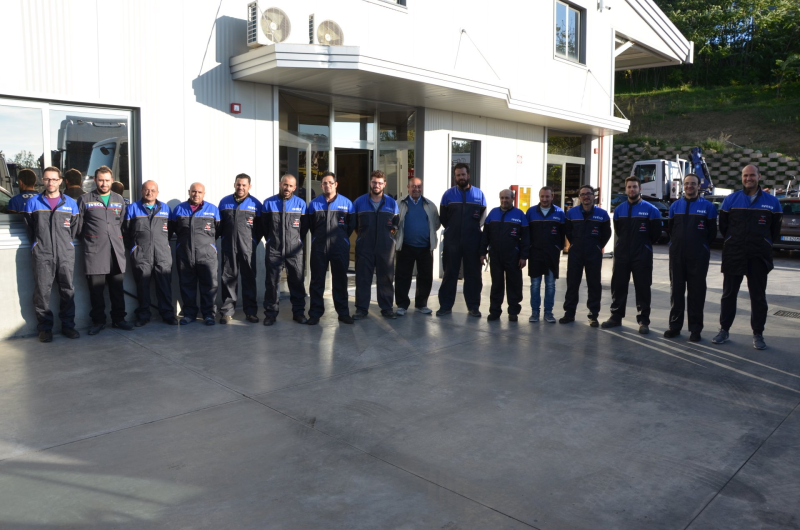 Un gruppo di uomini in uniforme blu e nera si trova fuori da un edificio dotato di aria condizionata.