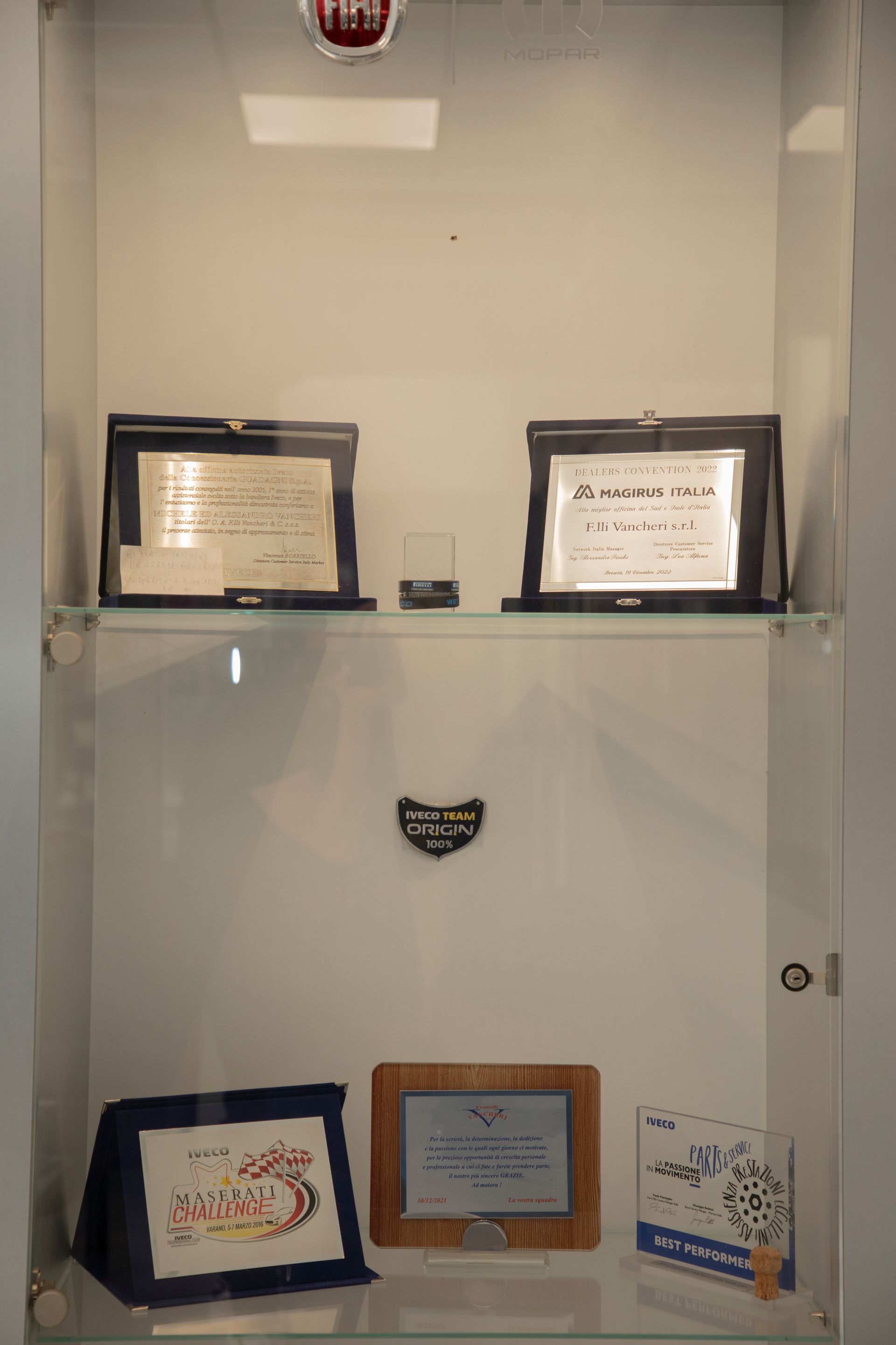 Una vetrina con premi e cimeli incorniciati.