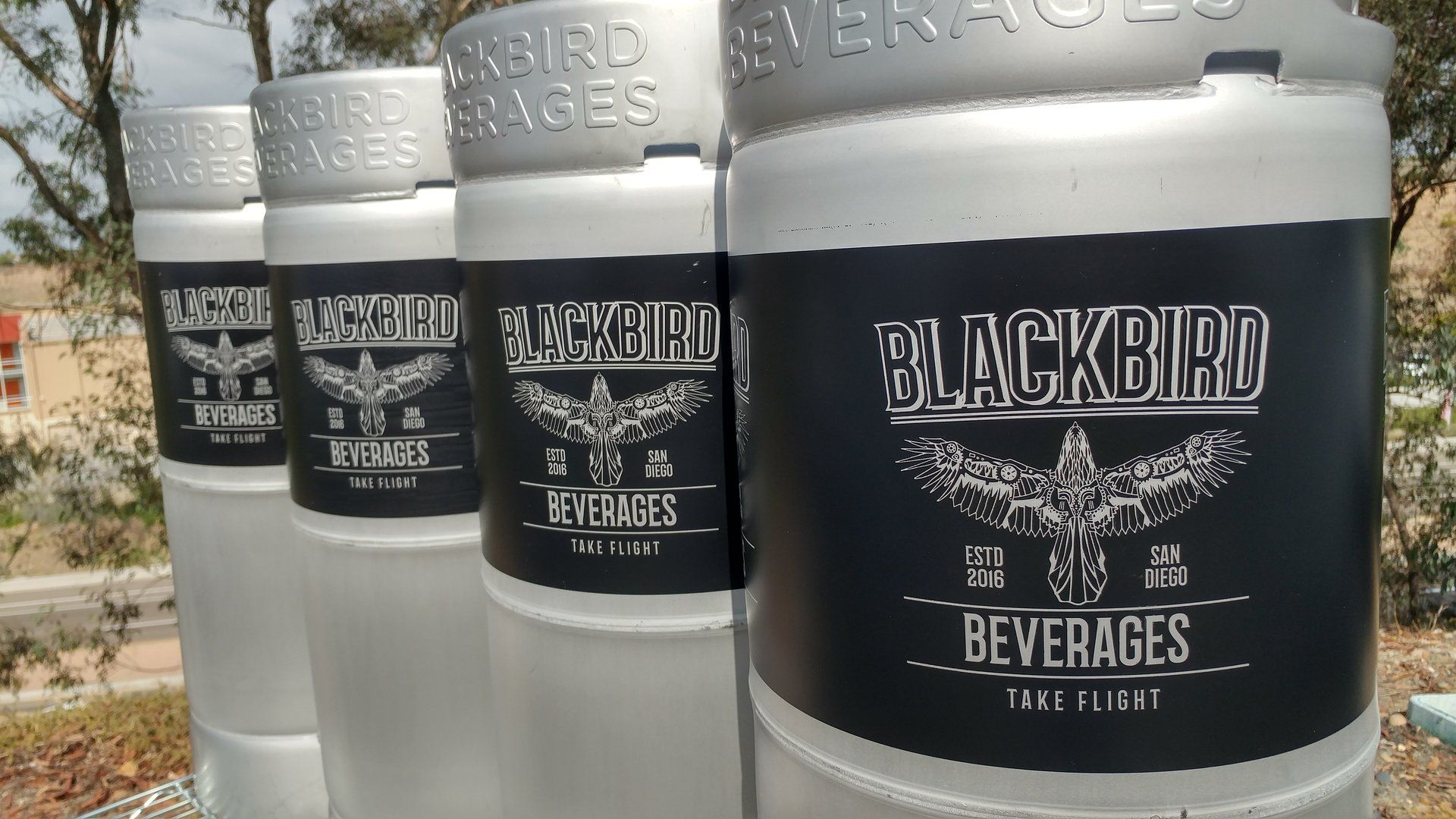Silver beer kegs with black labels reading