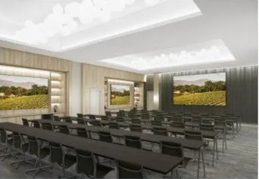 Rendering of the hotel's meeting room set for a presentation and video conference call.