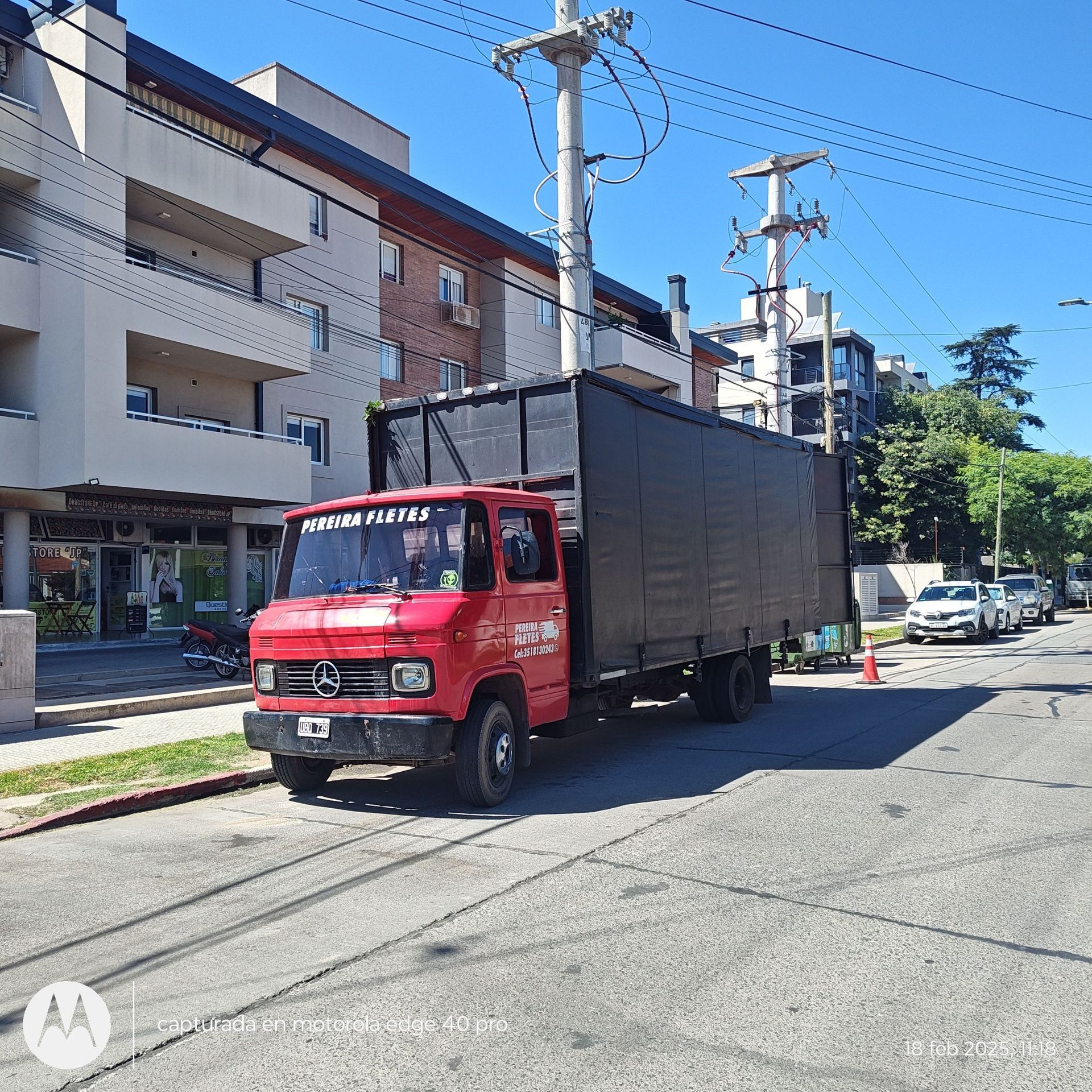 Un camión Mercedes rojo está estacionado al costado de la carretera.