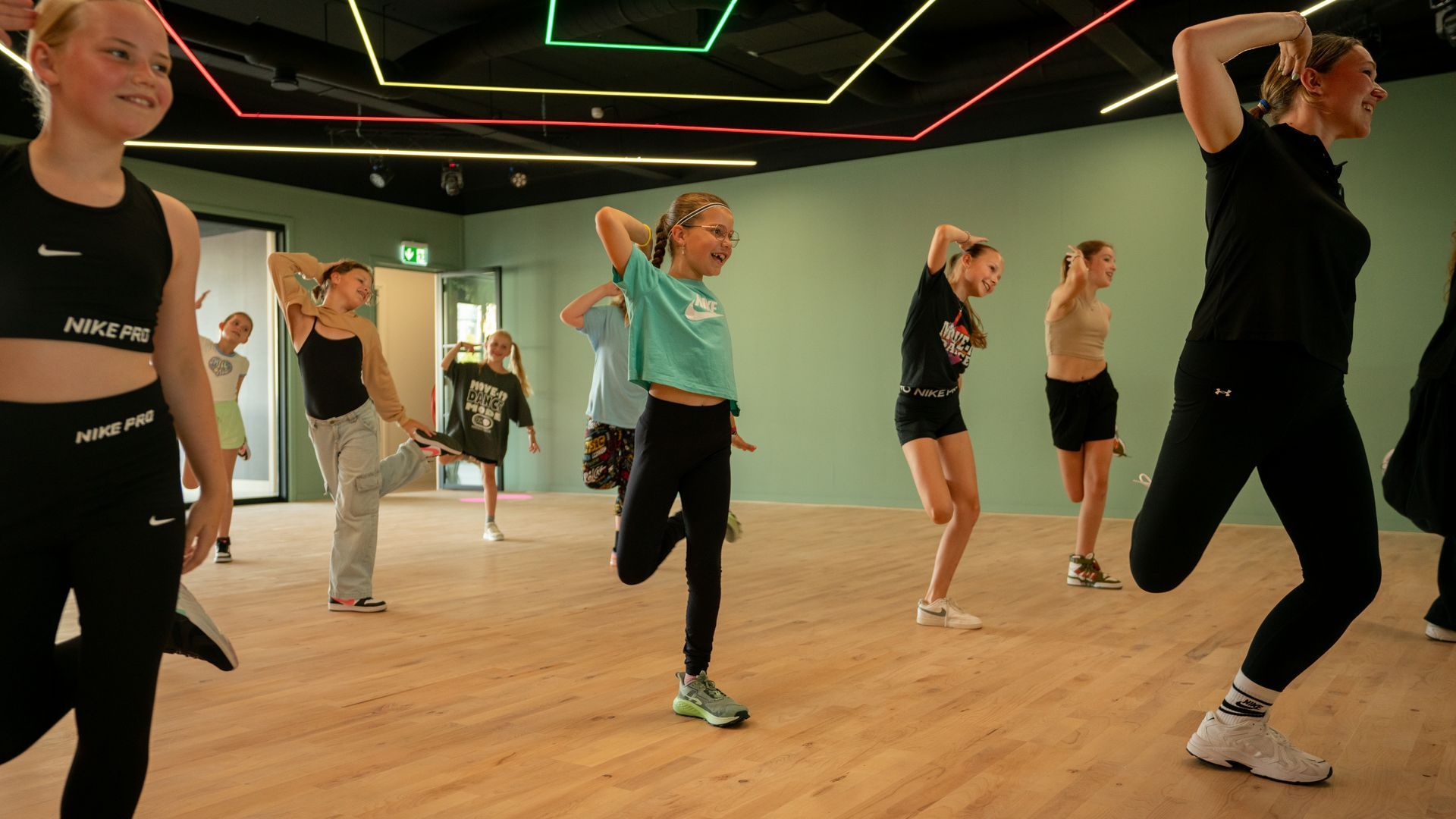 Een groep mensen danst op de dansvloer.