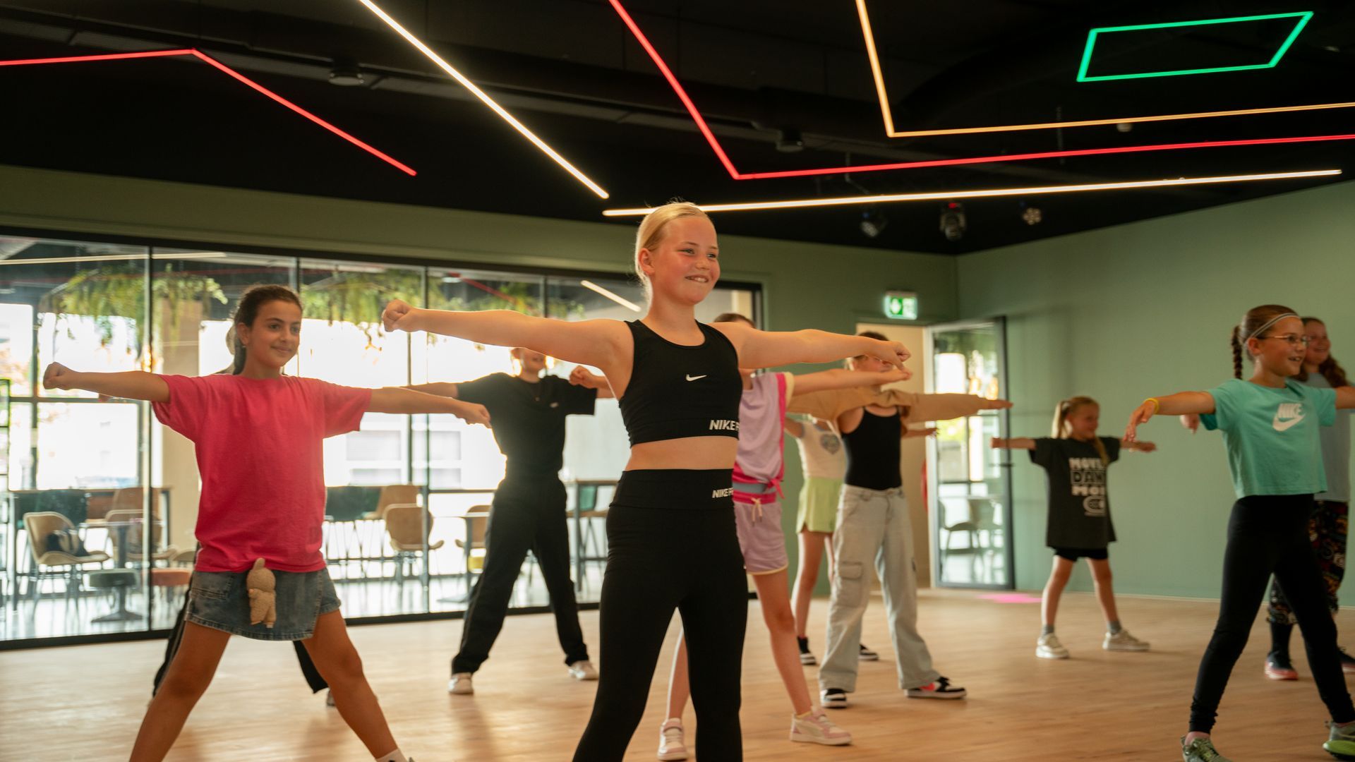 Een groep jonge meisjes danst op een podium.