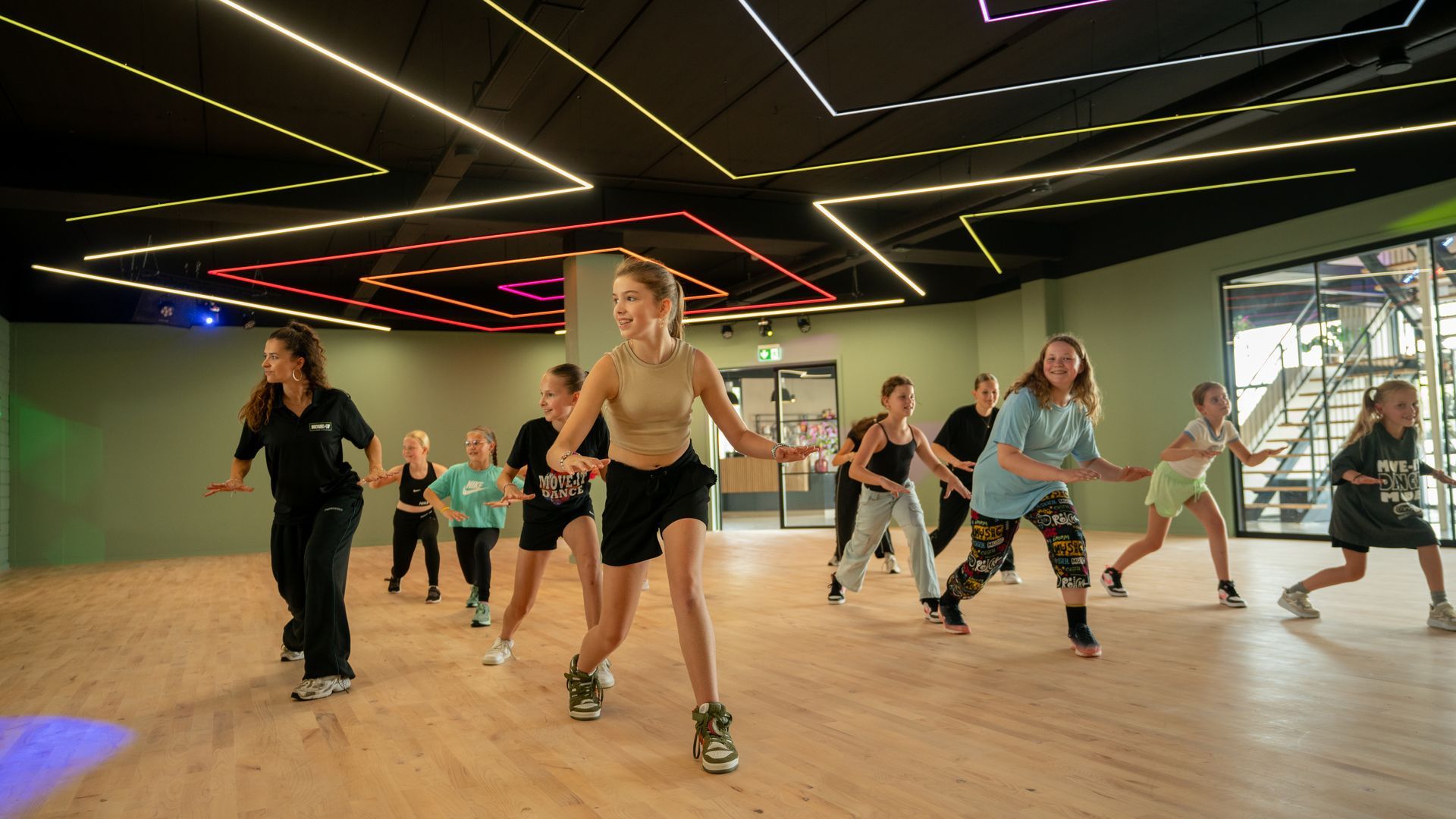 Een groep mensen danst in een dansstudio.