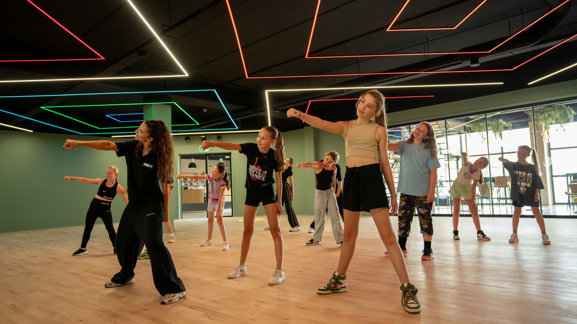 Op een zwart-witfoto is een groep kinderen te zien die op een podium danst.