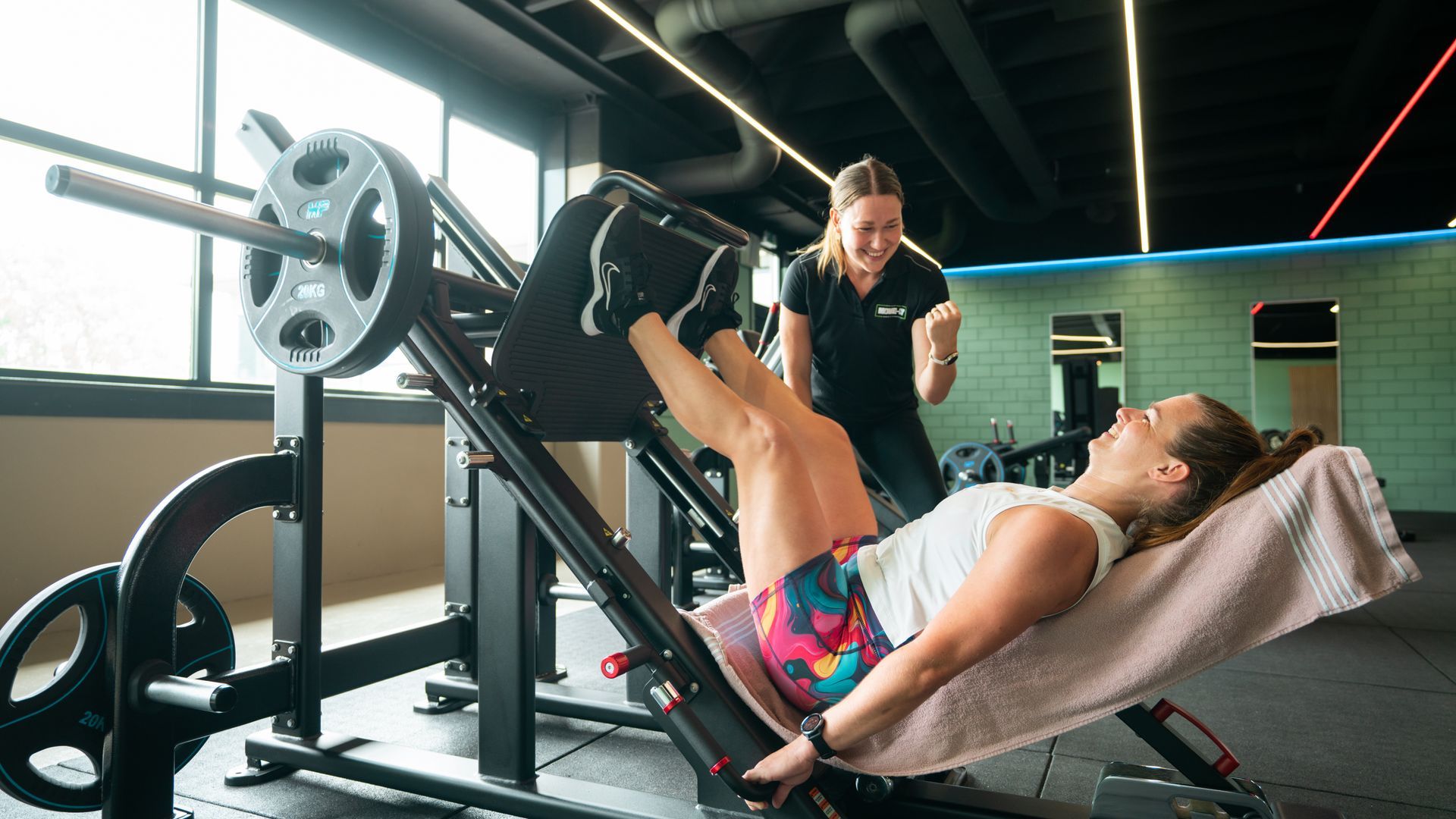 Een vrouw doet push-ups met een halter in een sportschool.