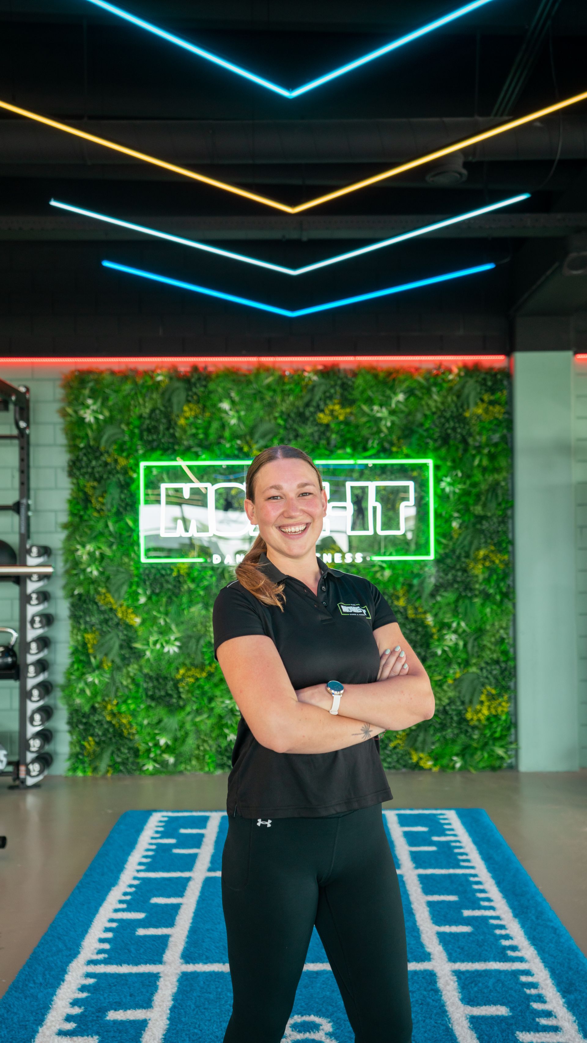 Een man en een vrouw poseren voor een foto in een sportschool.