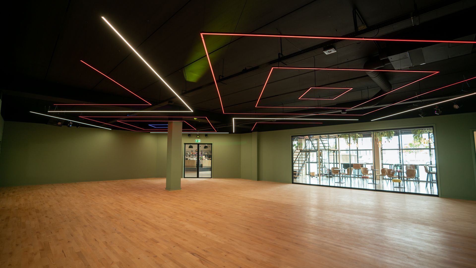 Een groep mensen danst in een grote ruimte.