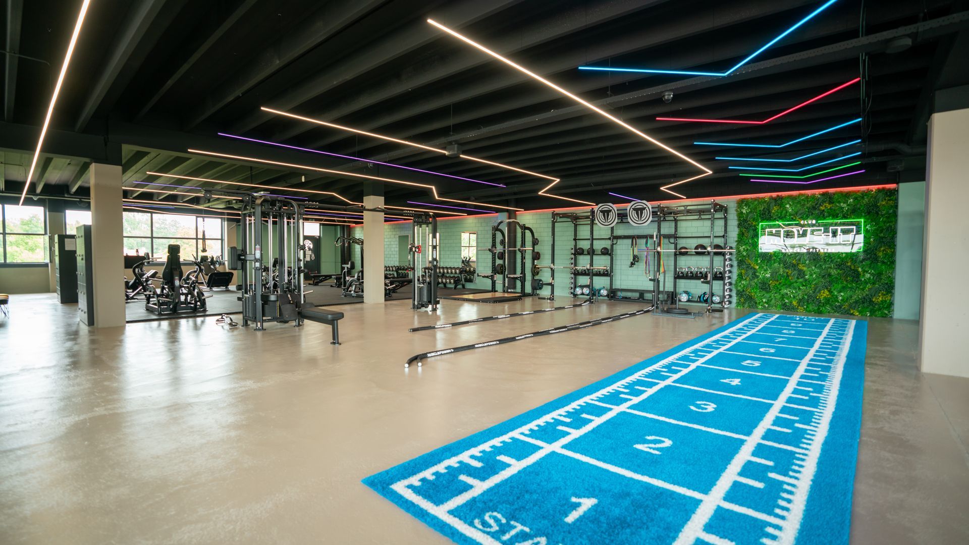 Een sportschool met veel fitnessapparatuur en een bank