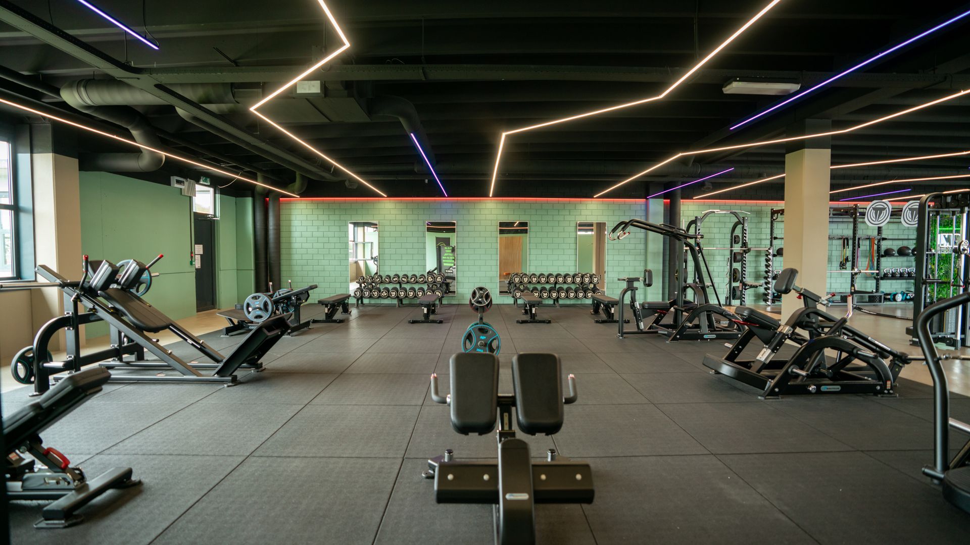 Een man zit op een hometrainer in een sportschool.