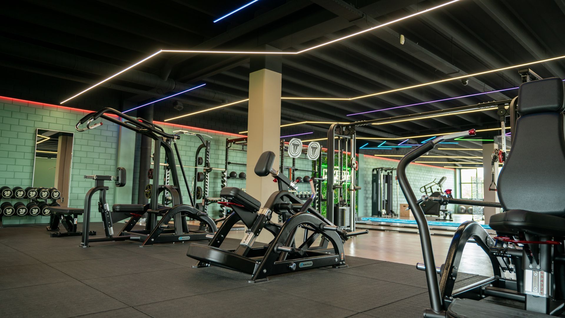 Een vrouw doet een plank met een halter in een sportschool.