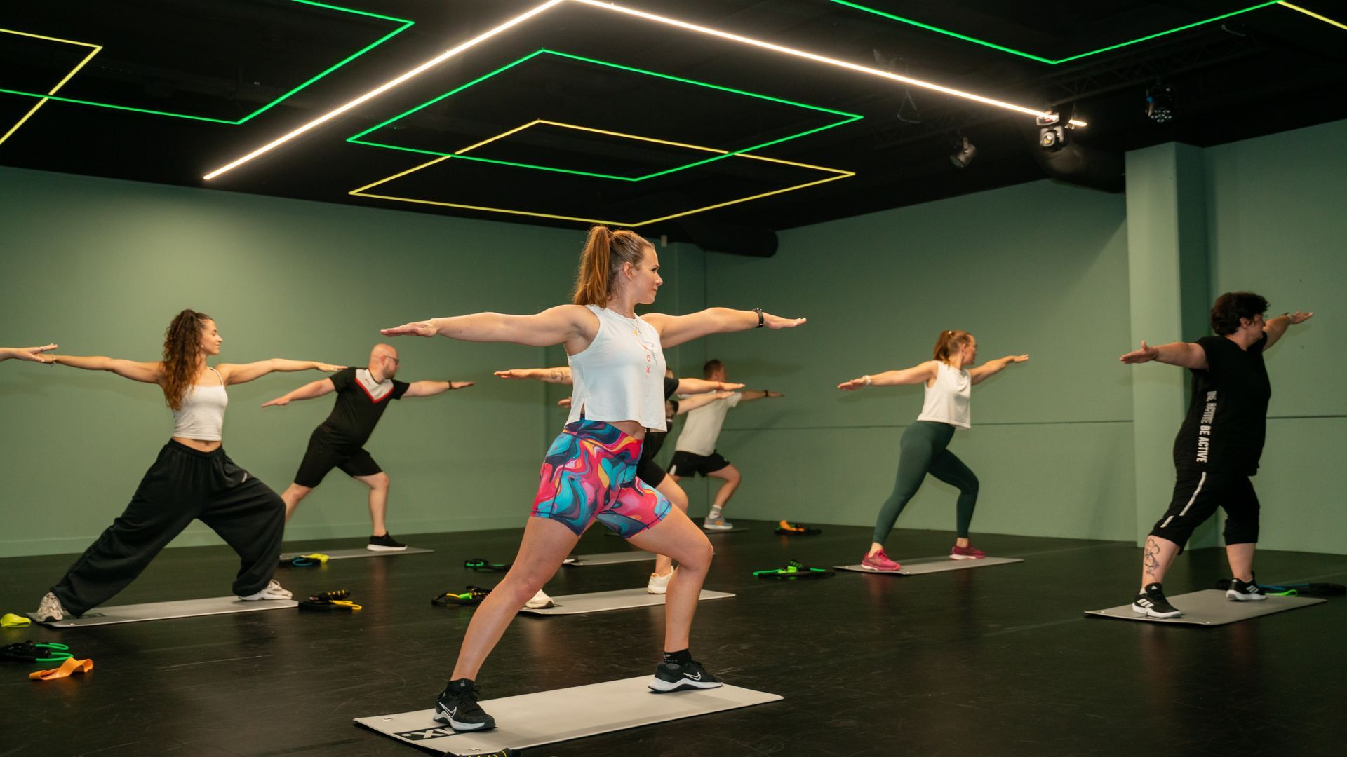 Een vrouw doet een yogahouding op een roze mat.