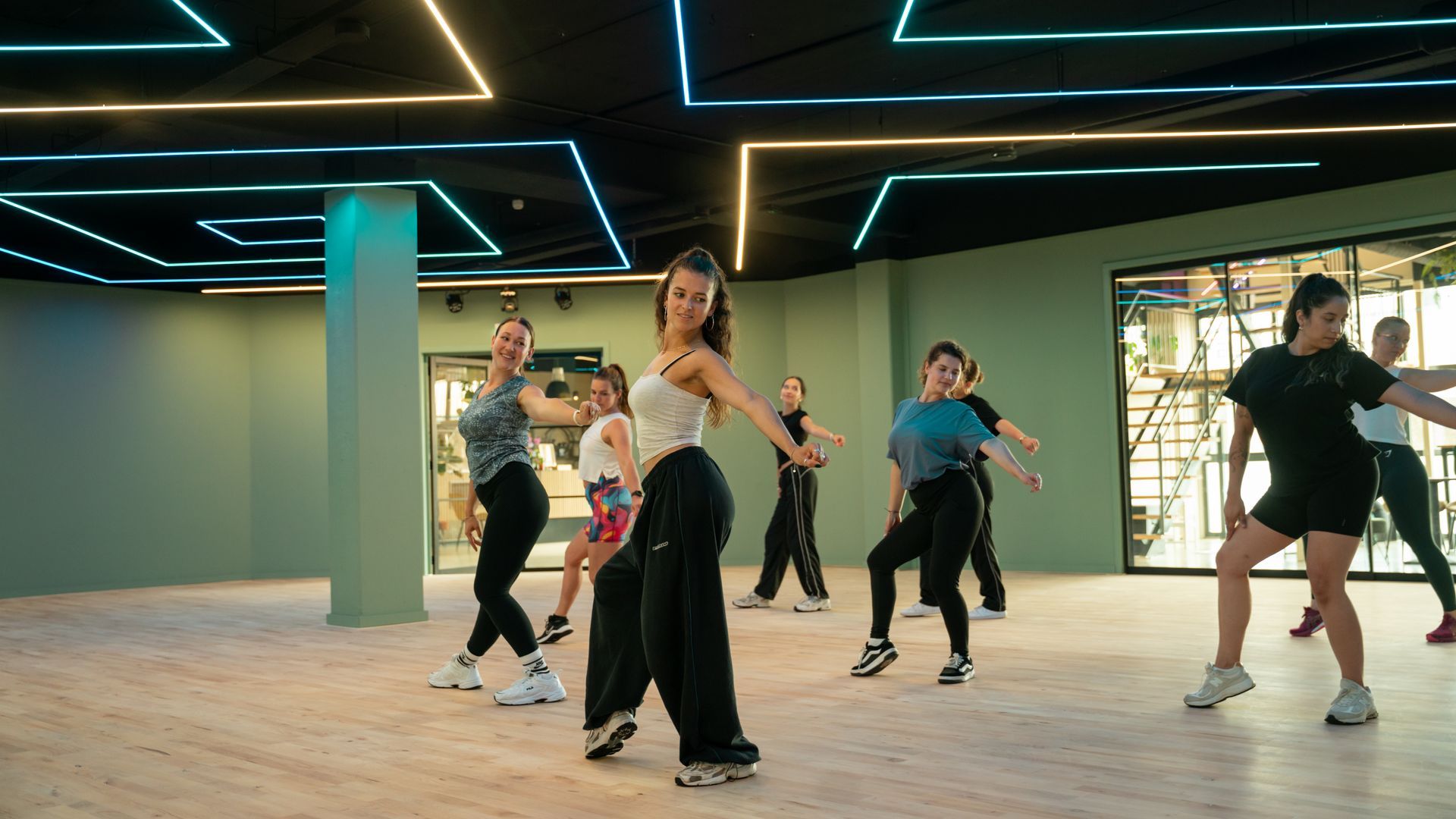 Een groep vrouwen doet oefeningen in een sportschool.