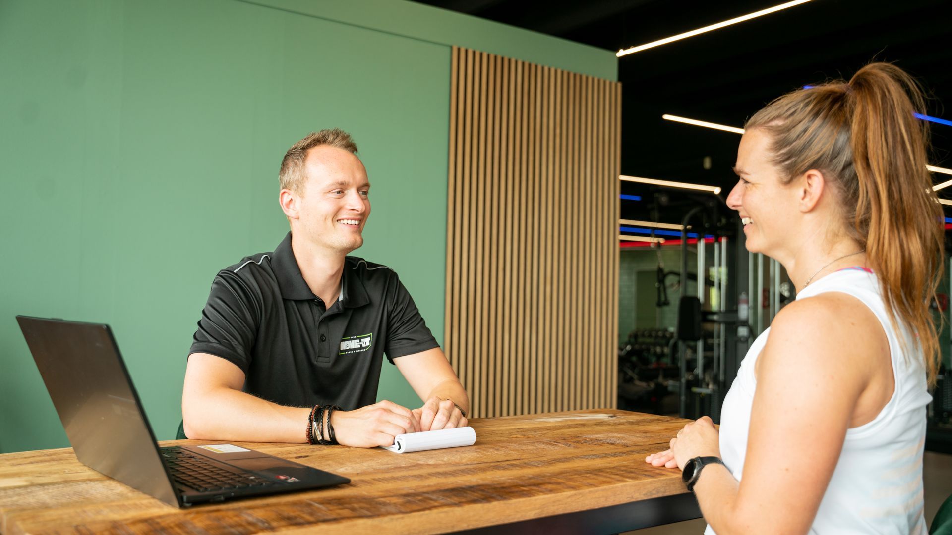 Een persoon ligt op een yogamat naast twee halters.