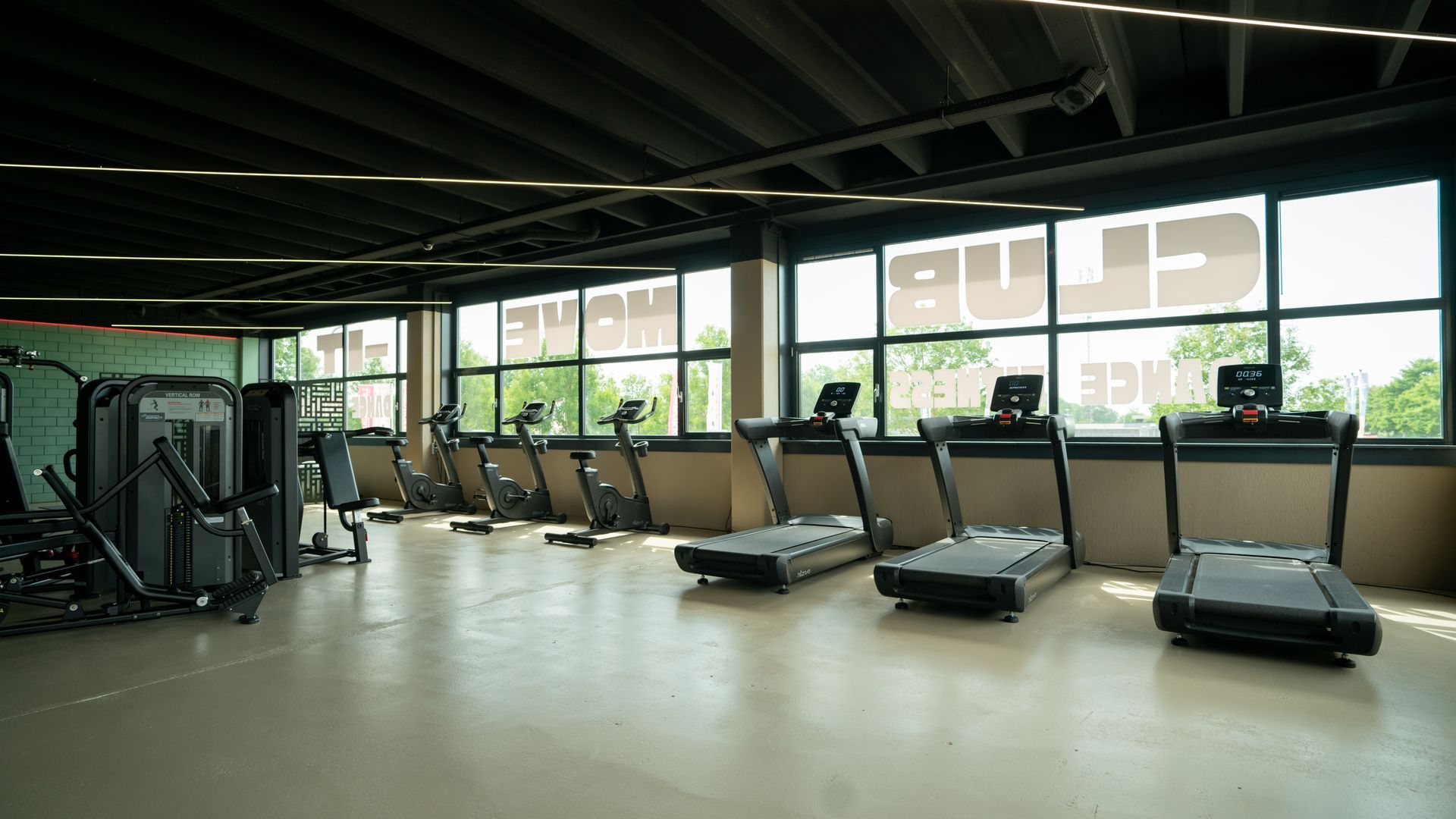Twee vrouwen zitten op yogamatten op de vloer van een kamer.