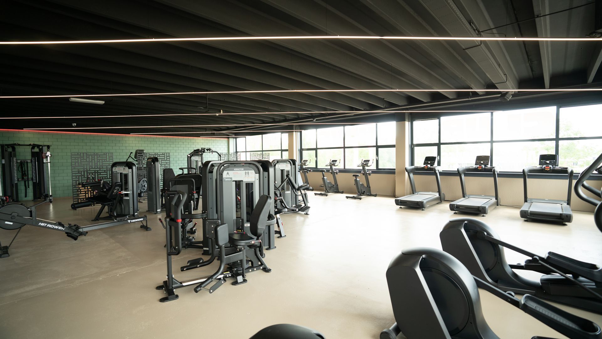 In een sportschool staan ​​drie elliptische machines op een rij.