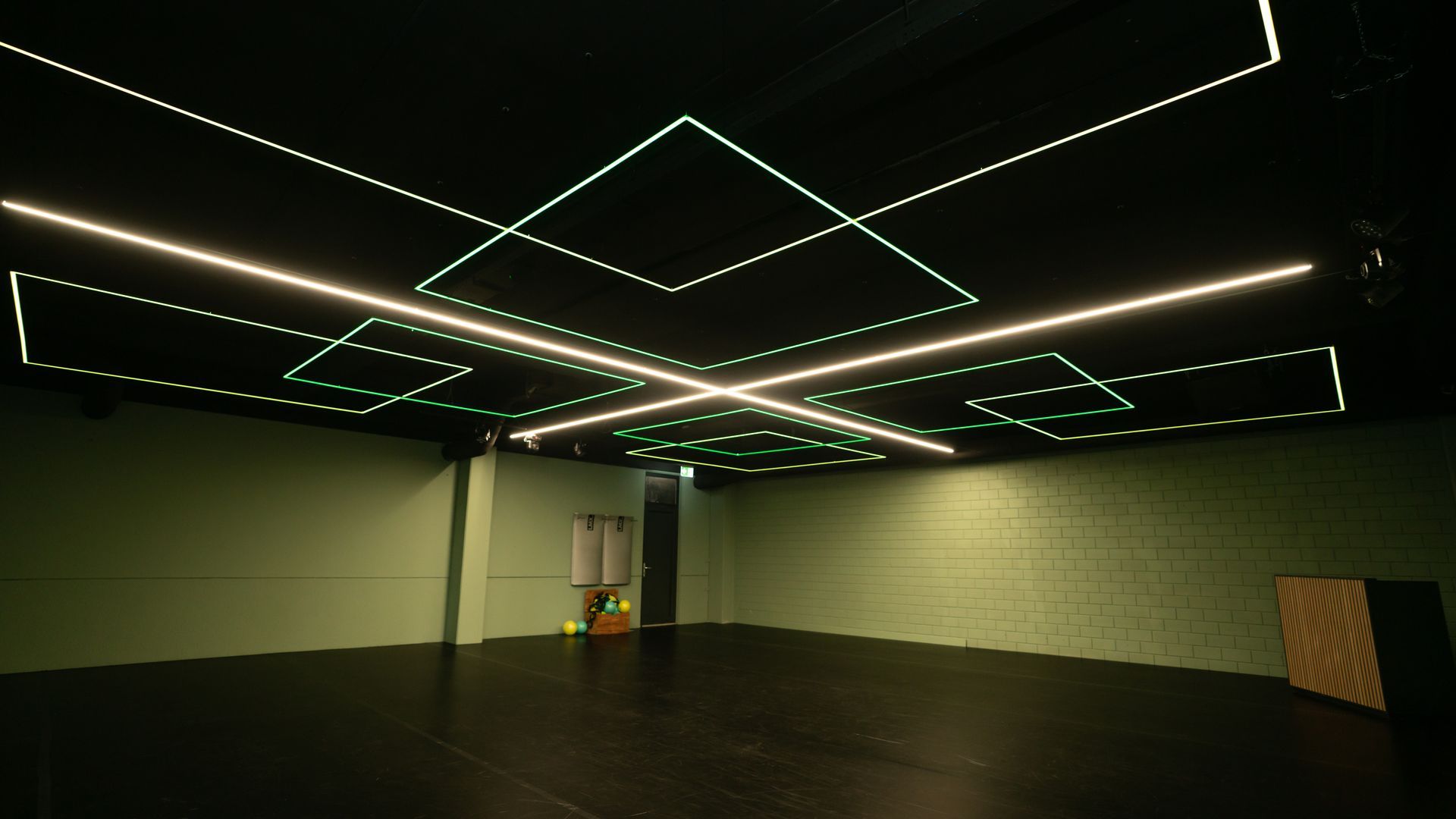 Een bruid en bruidegom omhelzen elkaar onder een kroonluchter.