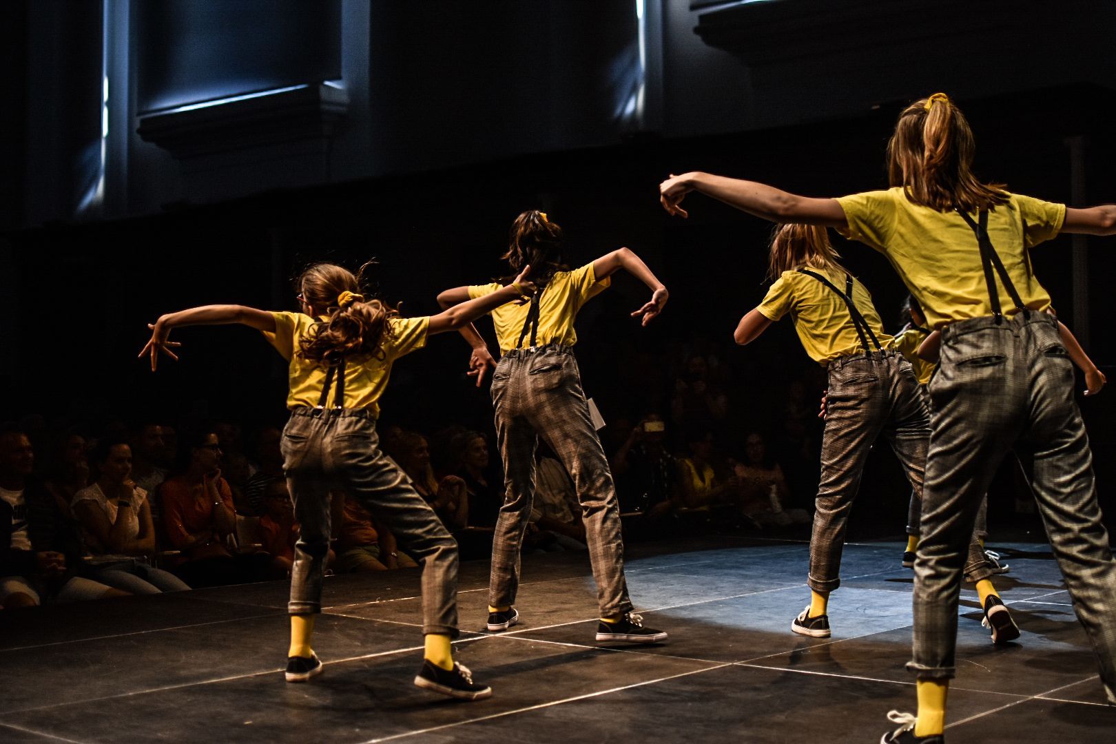 Een groep dansers treedt op op een podium.