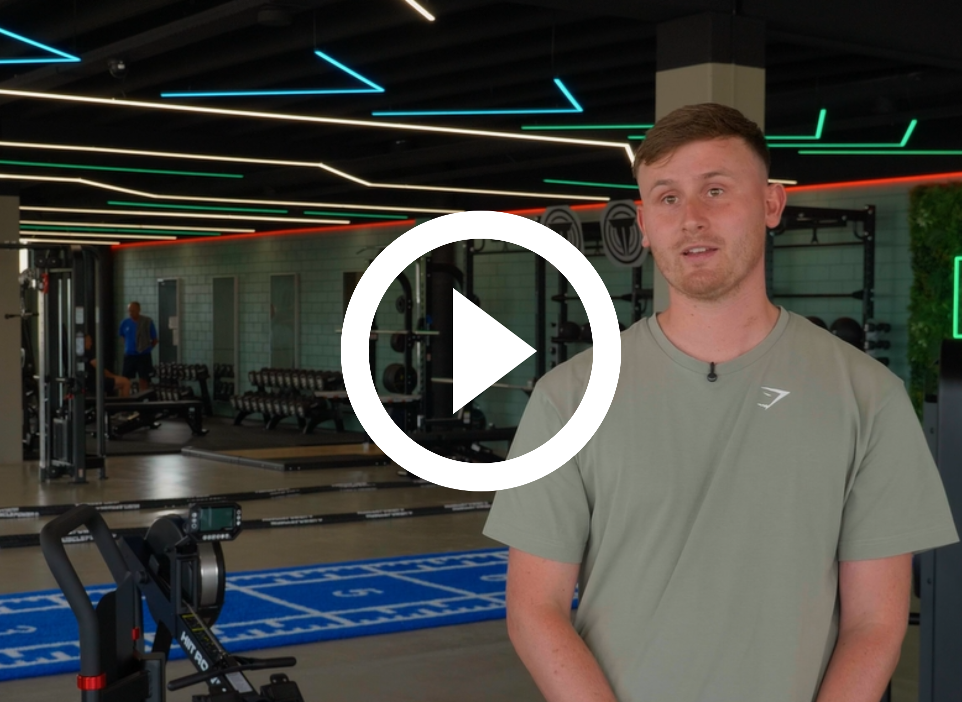 Een man in een under armour shirt staat in een sportschool