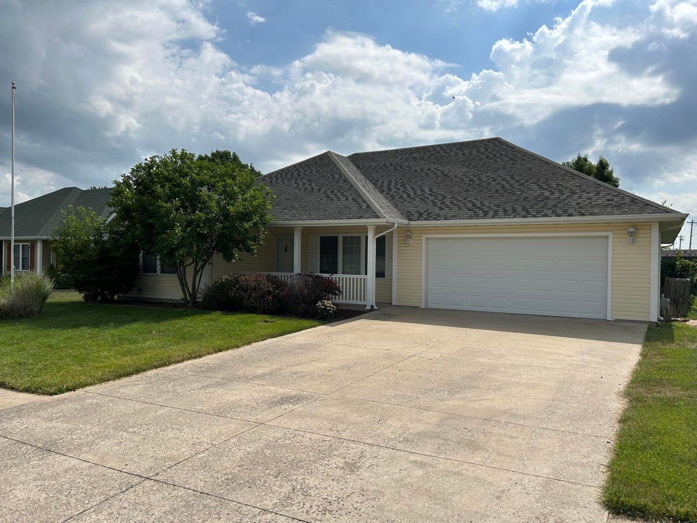 A house with a garage and a driveway in front of it.