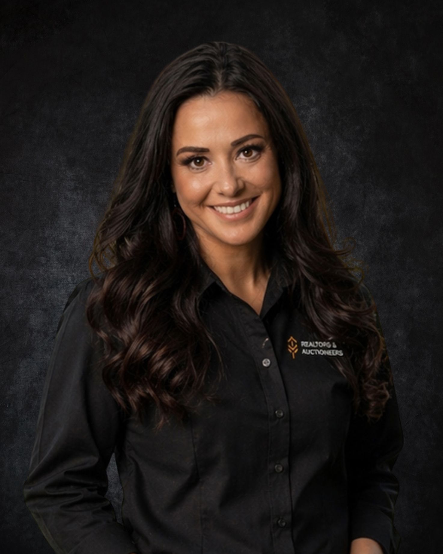 Woman in black shirt smiles at the camera against a dark background.