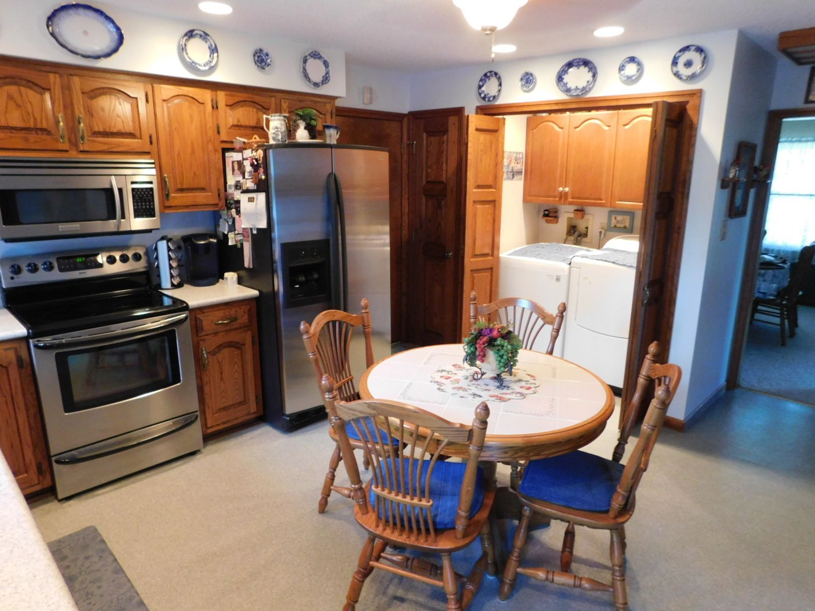 A kitchen with a table and chairs and a refrigerator