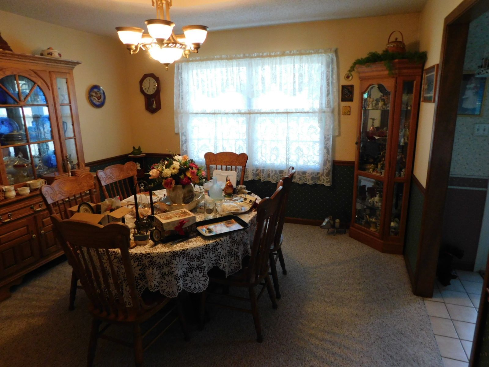 A dining room with a table and chairs and a clock on the wall