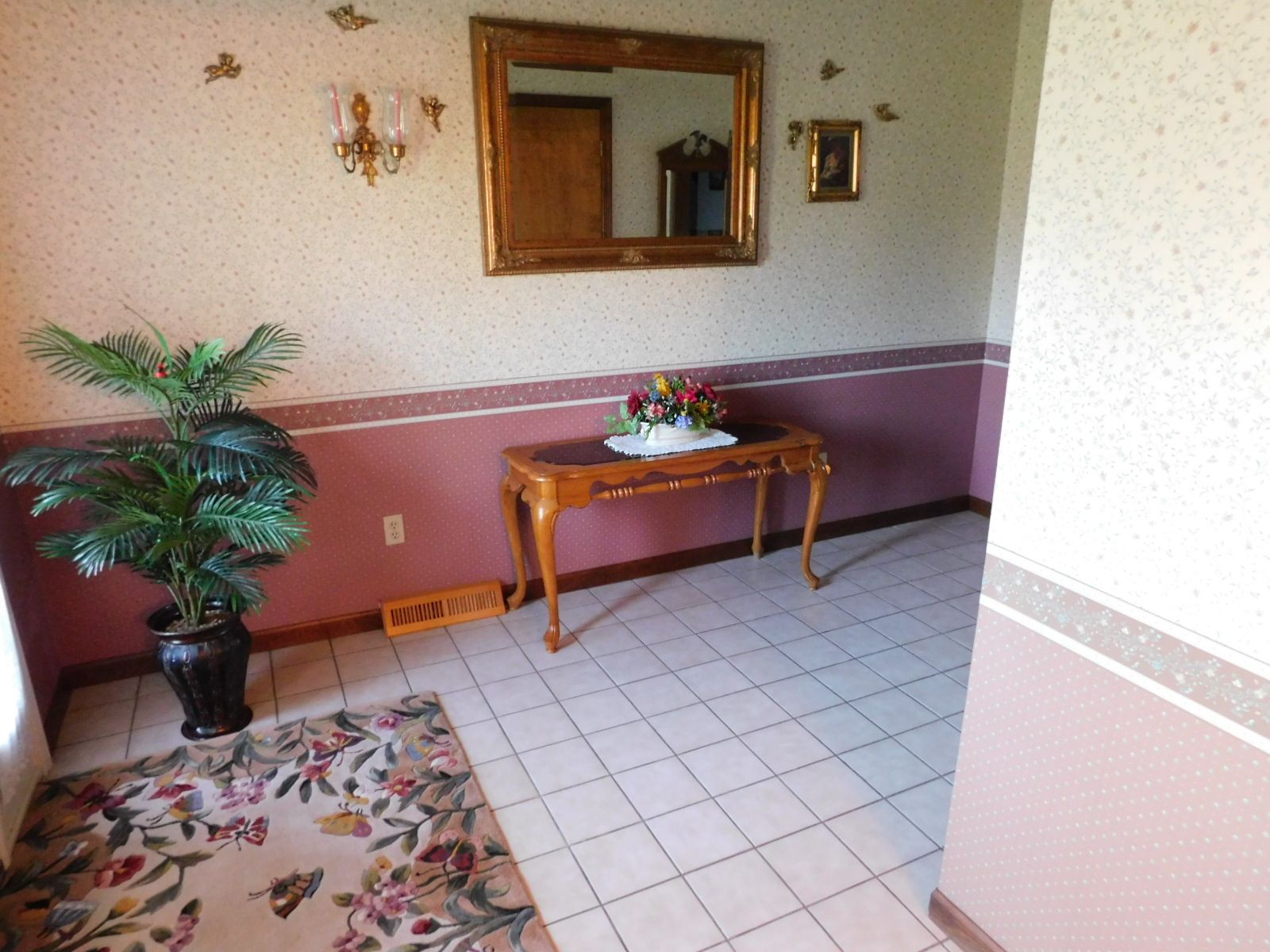 A hallway with a table and a mirror on the wall