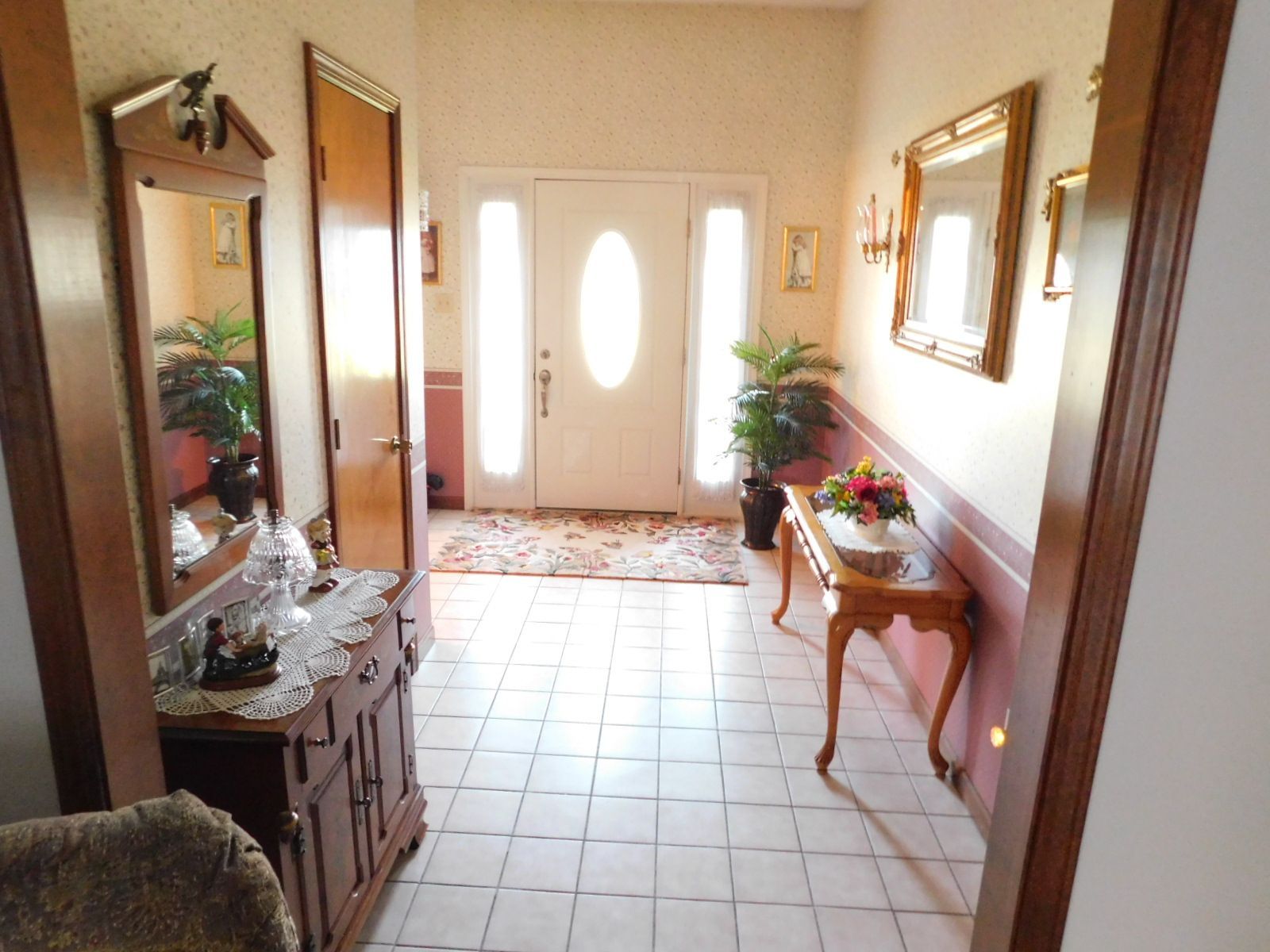 A hallway with a mirror and a table in it