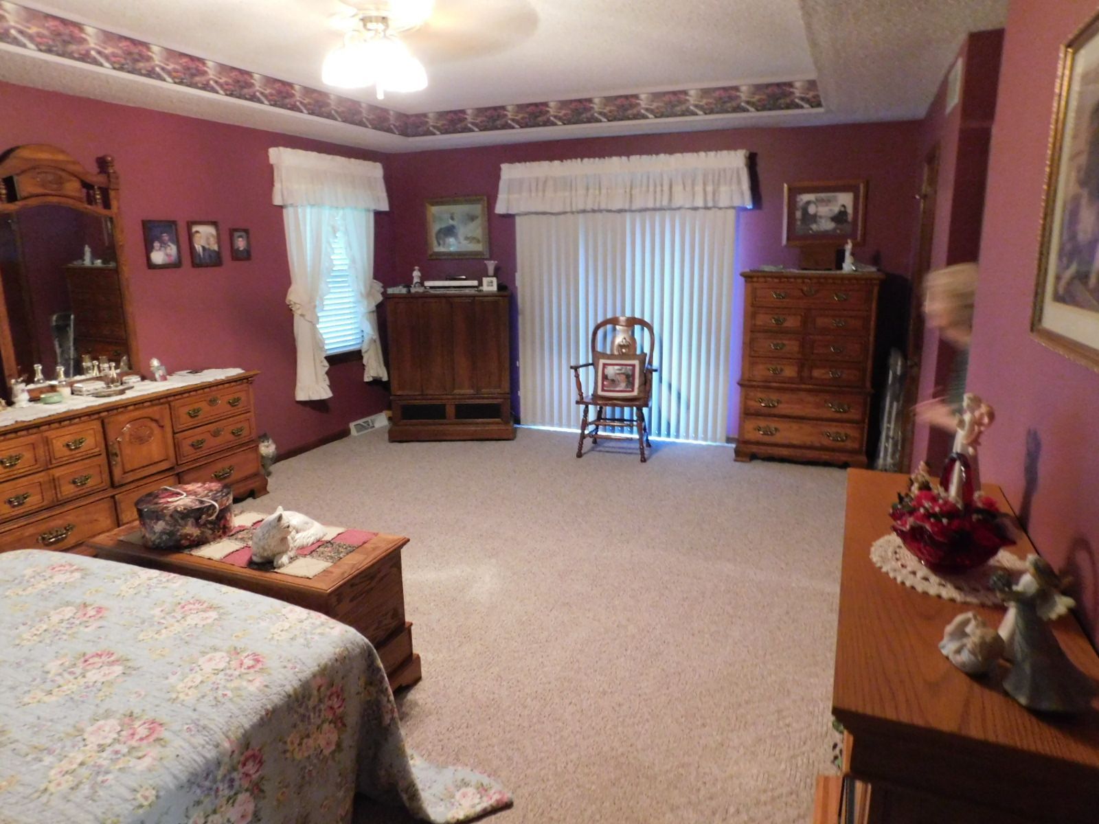 A bedroom with a bed dresser mirror and chair