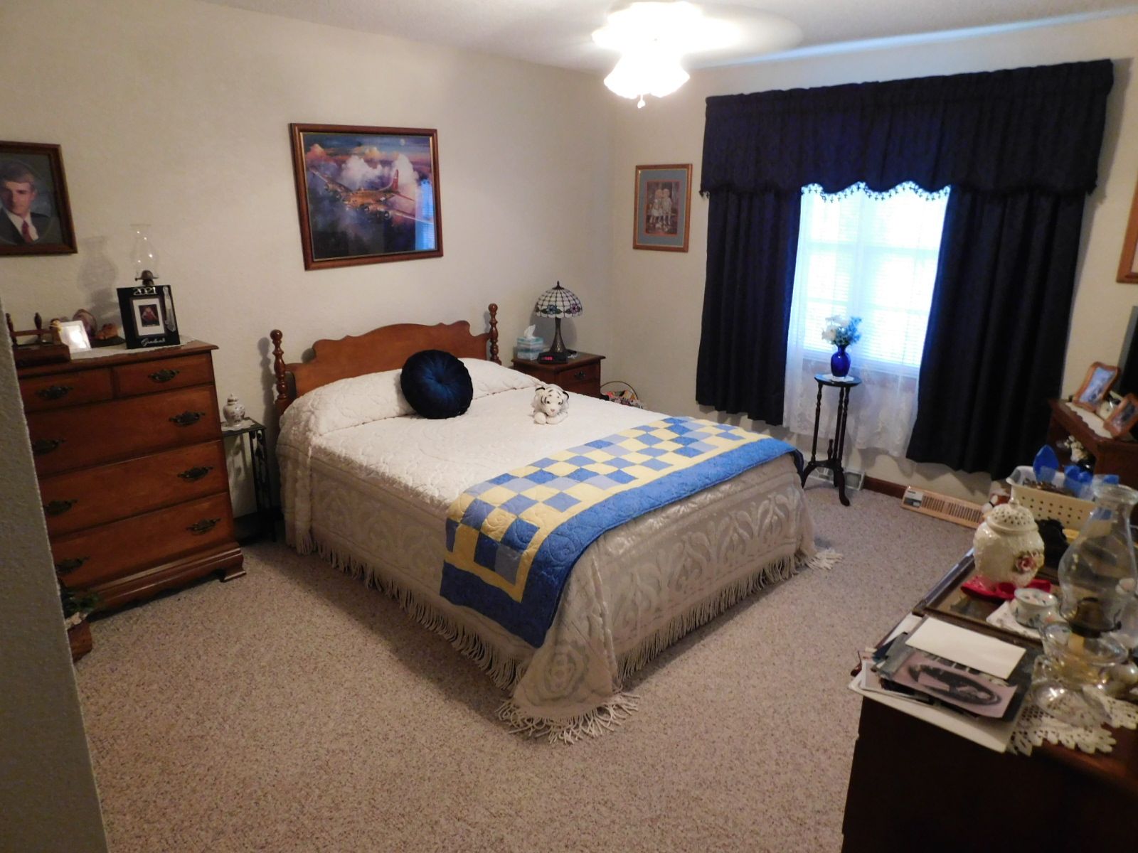 A bedroom with a large bed and a dresser