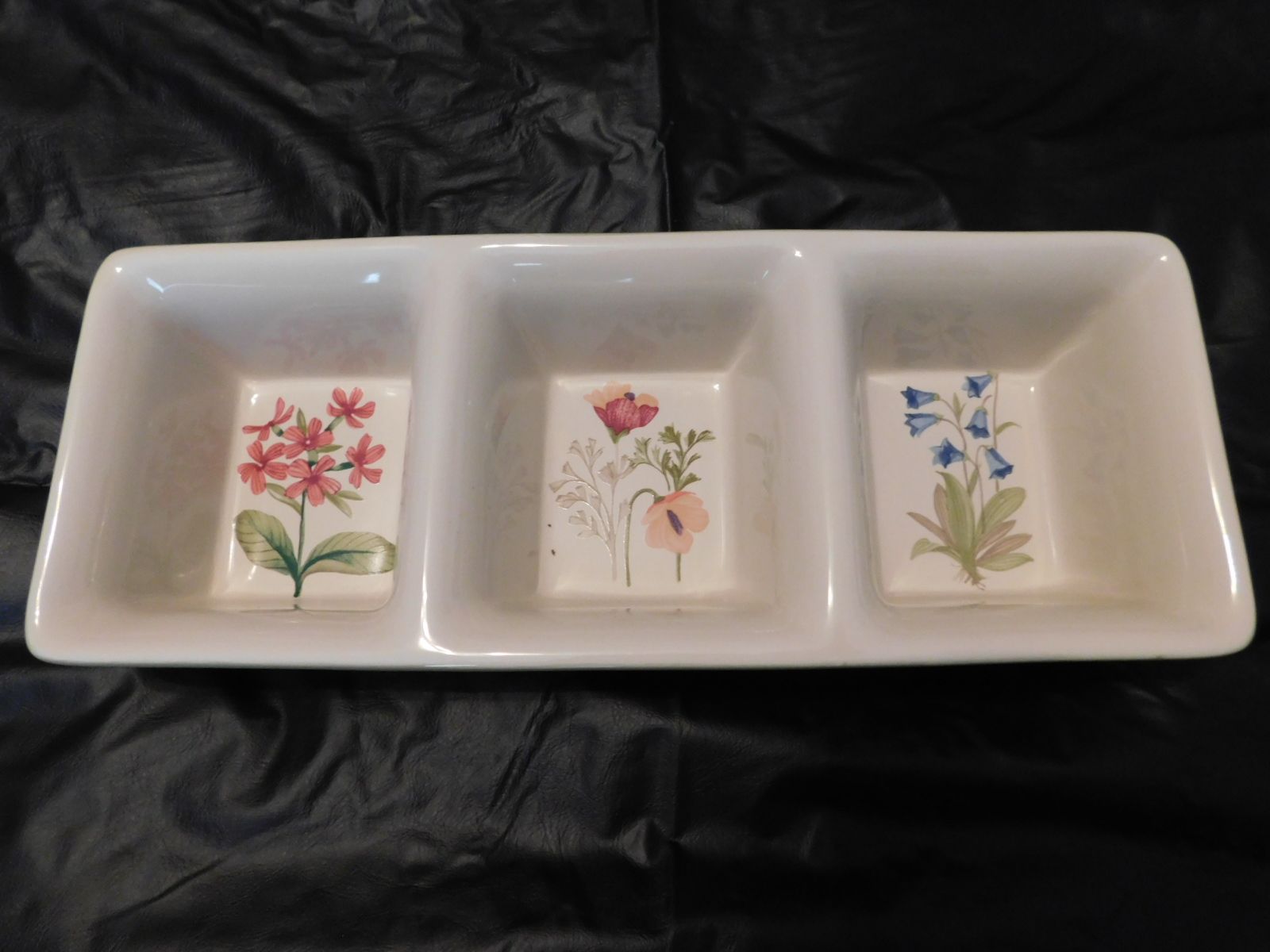 A white tray with three squares with flowers on them