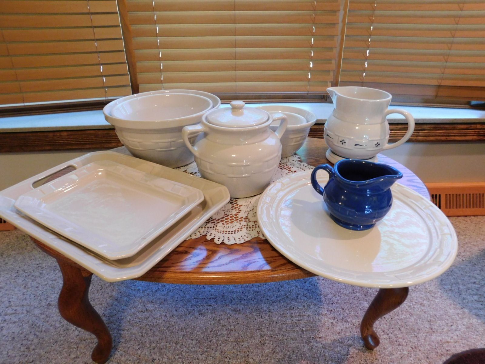 A table with plates , bowls , and pitchers on it