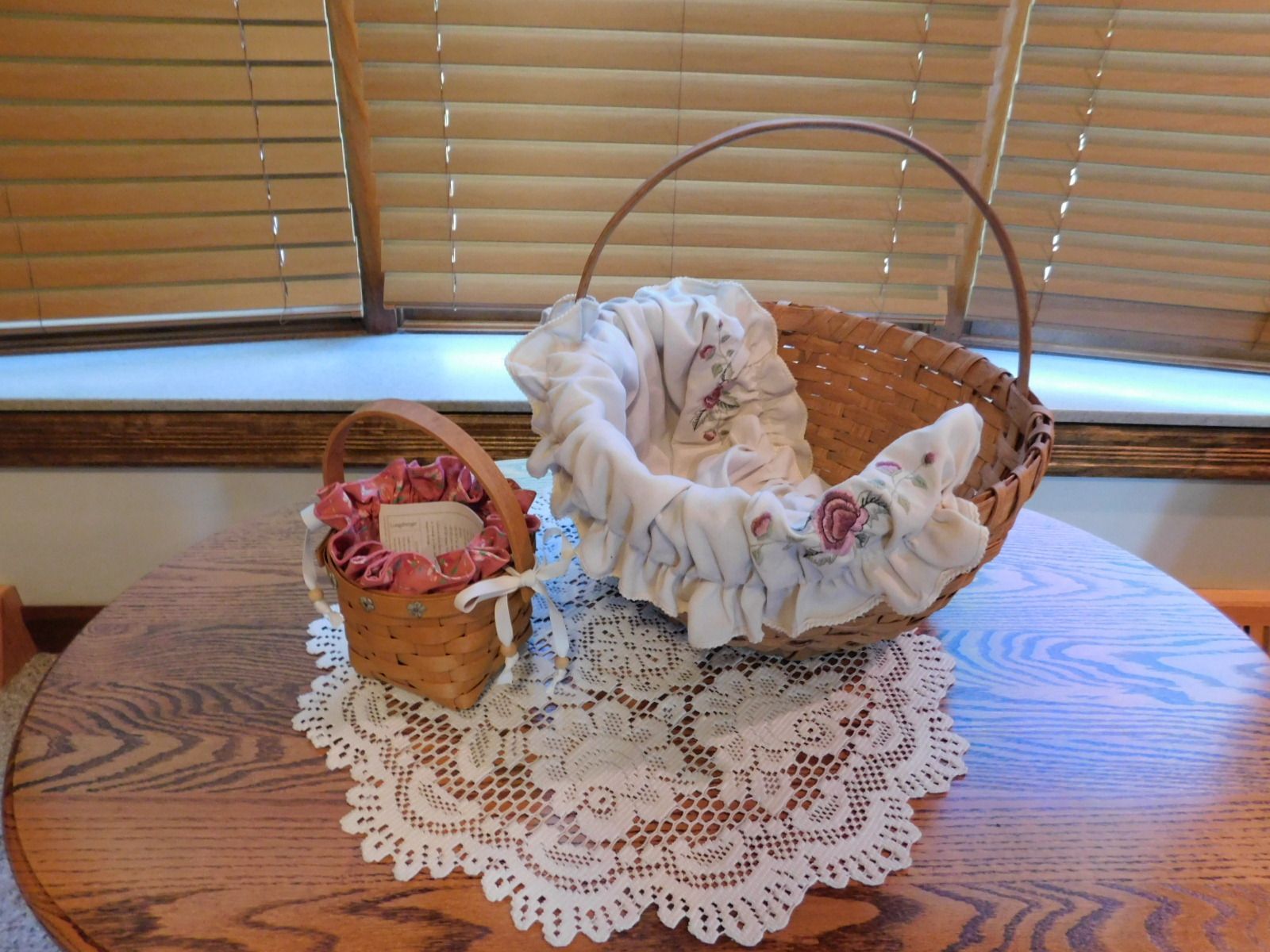 Two baskets are sitting on a wooden table in front of a window