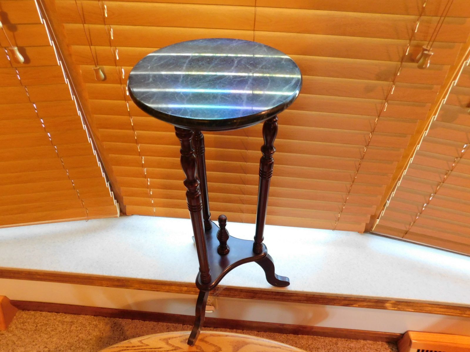 A small table in front of a window with blinds