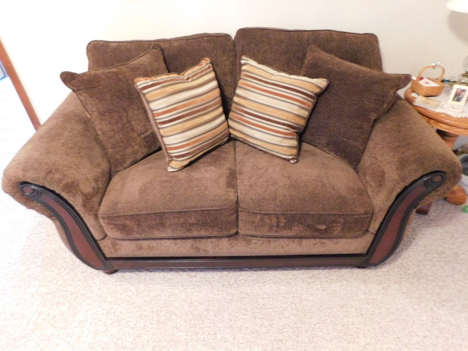 A brown couch with striped pillows on it