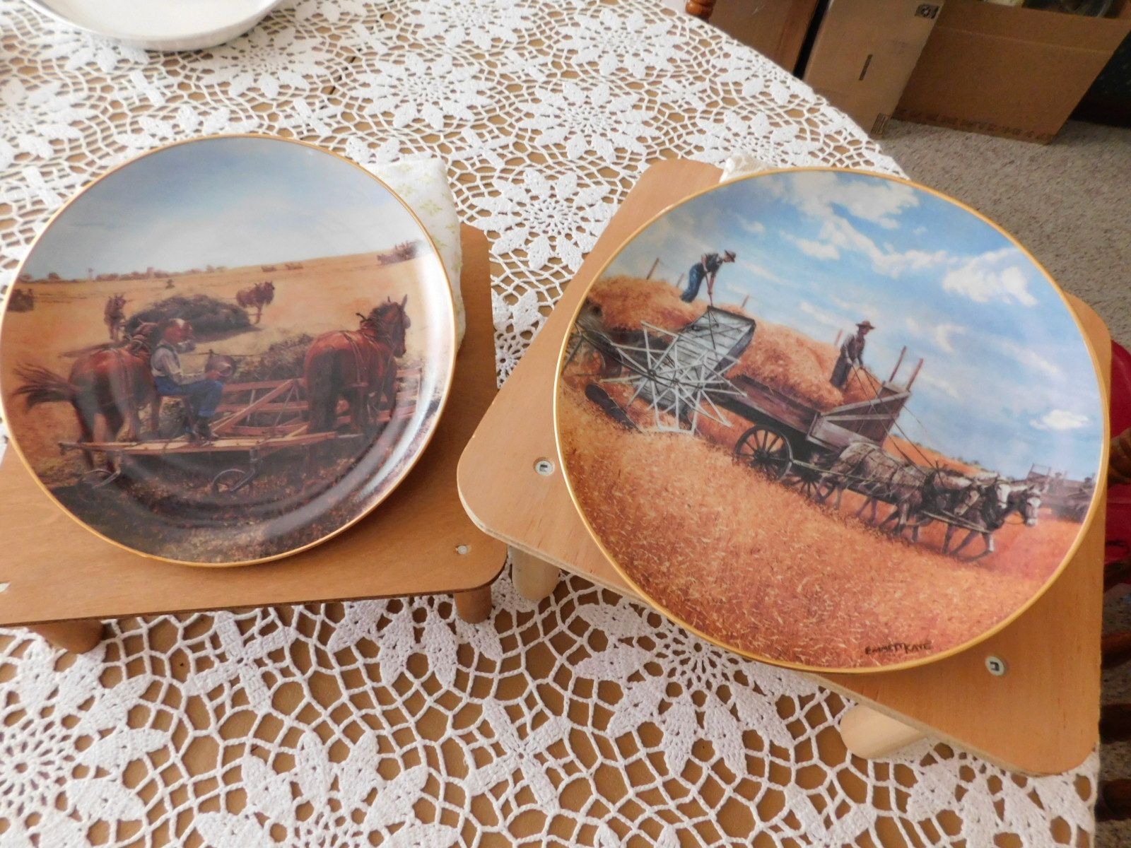 Two plates on a table one of which has a horse drawn plow on it