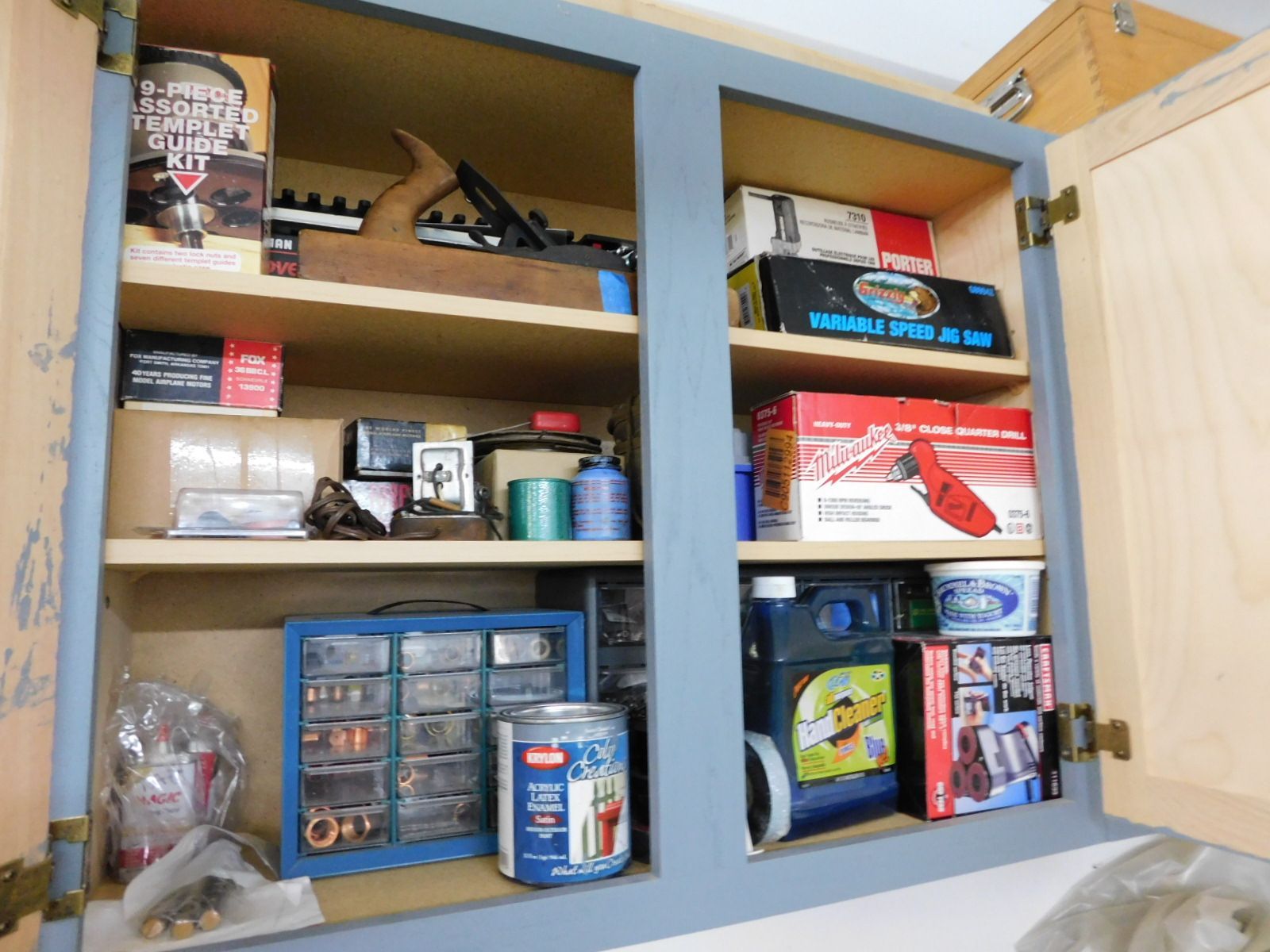 A cabinet filled with lots of tools and a box that says ' simpson ' on it