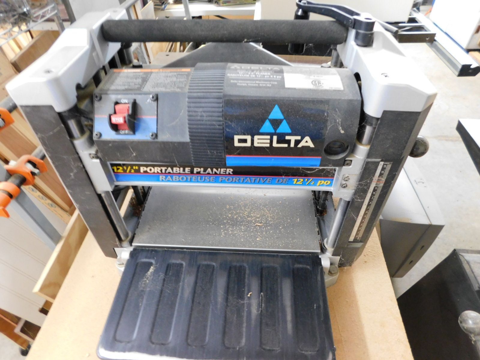 A delta portable planer sits on a wooden table