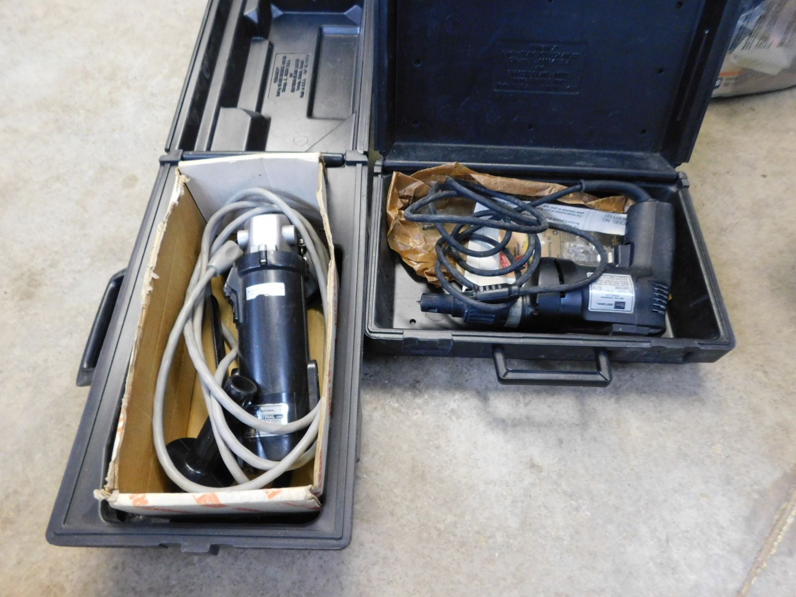 Two black cases with tools inside of them one of which has a cord coming out of it
